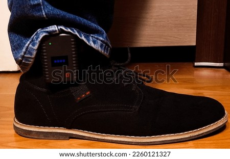 A close-up of a GPS tracking device attached to a man's leg, for police surveillance of violent people Royalty-Free Stock Photo #2260121327