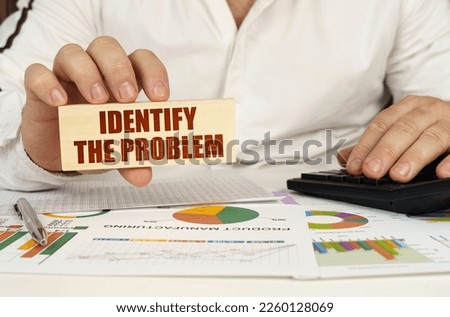 Business concept. On the table are business charts and diagrams in the hands of a wooden block with the inscription - Identify the Problem Royalty-Free Stock Photo #2260128069