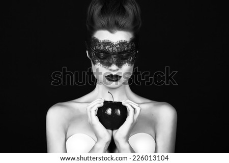 Beautiful young girl witch sorceress with a bandage black lace holding ripe apple magic witchcraft tempted to bite tale Sleeping Beauty Halloween 