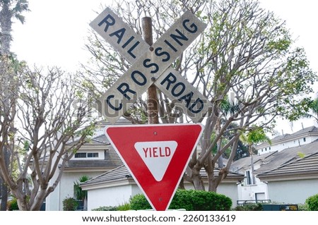 Rail road crossing and yield sign with trees