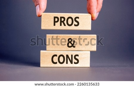 Pros and cons symbol. Wooden blocks with words 'Pros and cons'. Beautiful grey background, businessman hand. Business, pros and cons concept, copy space. Royalty-Free Stock Photo #2260135633