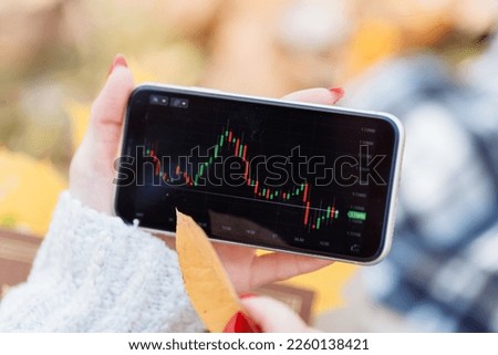 graph on the stock exchange in red and green colors on the phone. photographed with an old lens with blur around the edges. High quality photo. 