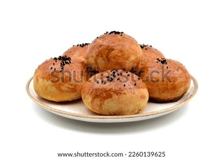 Homemade pastries , buns, Turkish "pogaca" in a round white plate, isolated on white background, closeup