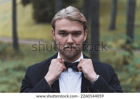 Portrait of an handsome Scandinavian blonde groom in a forest. High quality photo