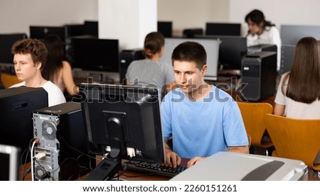 Modern boy student learning basics of programming in group course in computer college Royalty-Free Stock Photo #2260151261
