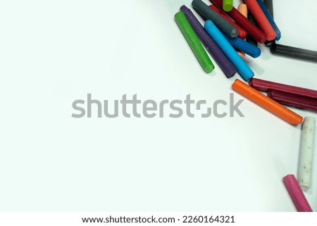 Assorted colors of oil pastels on a white background. The object is located in the upper right corner