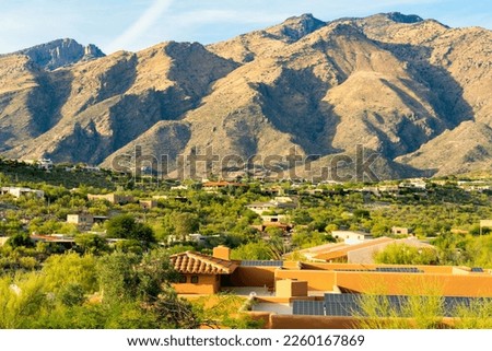 Towering moutains in the hills of arizona with clear blue sky and houses and homes on the desert ridge in north america. In rural part of the city with adobe style building designs on ridge of hill. Royalty-Free Stock Photo #2260167869