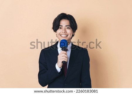 Young Asian man speaking with a microphone. Royalty-Free Stock Photo #2260183081