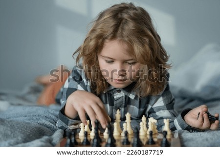 Kid play chess at home. Child think about chess game. Intelligent, smart and clever school kid pupil. Games for brain intelligence concept. Royalty-Free Stock Photo #2260187719