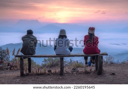 Tourists watch  Sunrise over mountain range and sea of fog  as seen from Den TV View Point, Muang Kong, Chiang Mai, Thailand