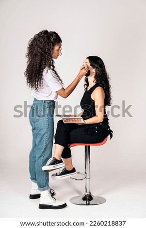 Stock photo of happy make up artist using eye shadow for her client’s look. Royalty-Free Stock Photo #2260218837