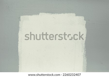 White paint on grey wall. Paint spot white. Smeared inscription. Poor wall painting. Royalty-Free Stock Photo #2260232407