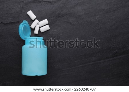Jar with chewing gums on black table, flat lay. Space for text