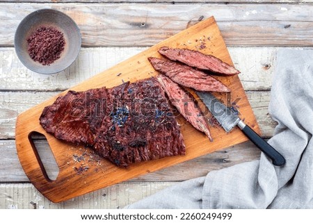 Barbecue wagyu bavette beef steak with red wine salt offered as top view on a rustic wooden board 
