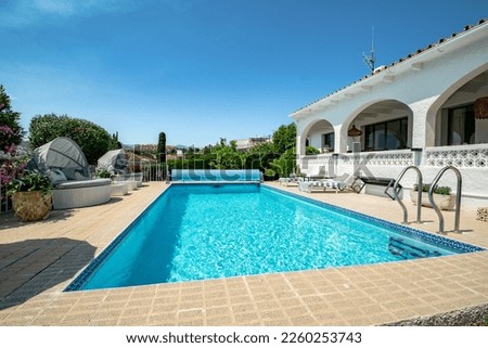 a image of a Mediterranean chalet with a swimming pool in the garden close up  Royalty-Free Stock Photo #2260253743