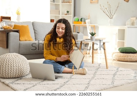 Female student doing homework at home Royalty-Free Stock Photo #2260255161