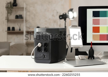 Portable power station and devices on table in photo studio