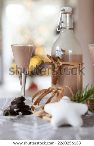 Alcoholic coffee liqueur in a bottle and glass made from chocoalte and coffee. Delicious drink for party or holidays. Closeup. Vertical.