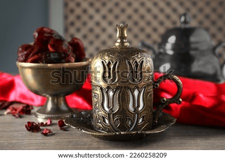 Tea and date fruits served in vintage tea set on wooden table, closeup