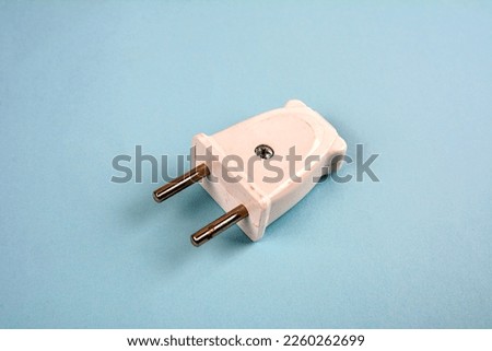 White two pronged plug on a blue background .Electric European plug isolated on a blue background.