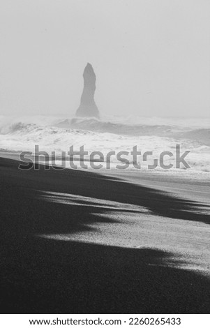Foggy Reynisfjara beach monochrome landscape photo. Beautiful nature scenery photography with rock on background. Idyllic scene. High quality picture for wallpaper, travel blog, magazine, article