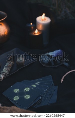 Close up using taro cards for ritual concept photo. Dark witchcore aesthetic. Front view photography with blurred background. High quality picture for wallpaper, travel blog, magazine, article