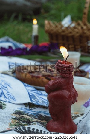 Close up burning candle on picnic concept photo. Forest picnic aesthetic. Front view photography with blurred background. High quality picture for wallpaper, travel blog, magazine, article