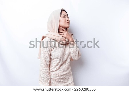 An Asian Muslim woman feels so thirsty because of the hot weather during the summer season while fasting Royalty-Free Stock Photo #2260280555