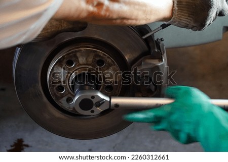 mechanic uses a pound wrench to tighten the car brake disc.car brake disc assembly
