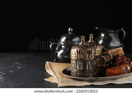 Tea and Turkish delight served in vintage tea set on dark grey textured table, space for text