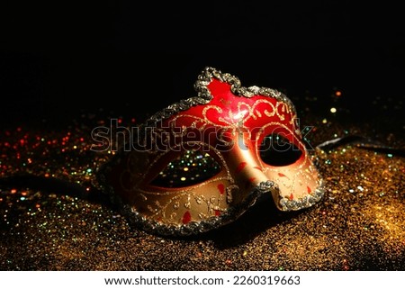Carnival mask with glitter for Mardi Gras celebration on dark background