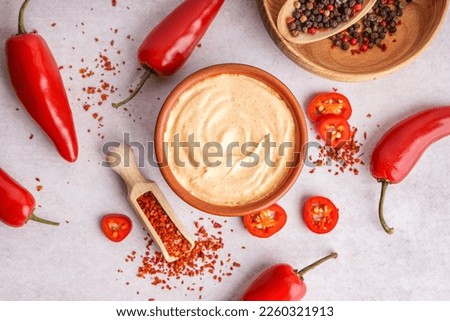 Bowl of tasty chipotle sauce and spices on light background Royalty-Free Stock Photo #2260321913