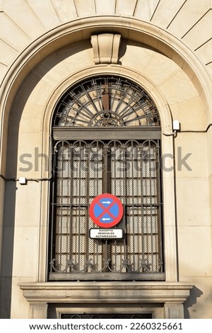 Traffic Sign Fixed to Ornate Arched Window with Metal Frame and Stone Surround