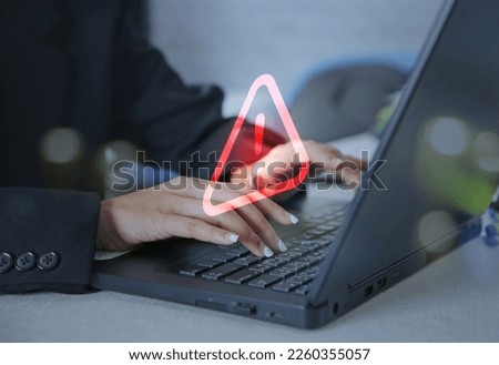 Businesswoman using computer laptop with caution warning sign for notification error concept.