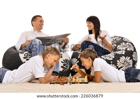 Happy  family is resting together at home playing chess isolated on white background