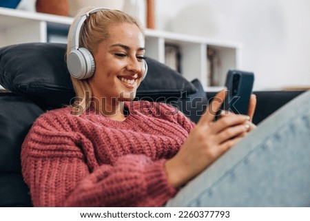 Blonde woman with headphones is having a video call Royalty-Free Stock Photo #2260377793