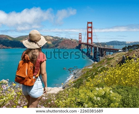 Woman standing on top of the mountain enjoying beautiful view. Girl sightseeing on summer vacation trip.  Golden Gate Bridge, over Pacific Ocean and San Francisco Bay, California, USA Royalty-Free Stock Photo #2260381689