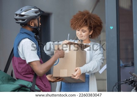 Black man, box and customer signing in ecommerce for delivery service, package or order at door. Happy African American female with courier guy with signature on clipboard for quality or feedback