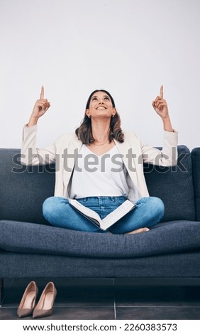 Reading, book and woman on sofa pointing for mockup, empty and blank copy space in living room. Advertising, marketing and girl on couch with story, literature and textbook for knowledge or research