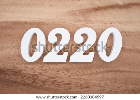 White number 0220 on a brown and light brown wooden background.