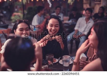 Pretty ladies bonding and laughing at a friend's joke while having dinner at a restaurant. Catching up with buddies after years of not seeing each other. Royalty-Free Stock Photo #2260396451