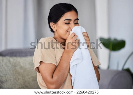 House, cleaning and woman smelling laundry on a sofa, happy and relax alone in her home. Fresh, linen and smiling domestic worker excited for freshness, results and soft fabric in household chores Royalty-Free Stock Photo #2260420275