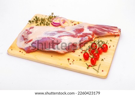 raw lamb leg with vegetables, loin on the bone with herbs, meat shoulder blade on a wooden cutting board, on a white isolated background Royalty-Free Stock Photo #2260423179
