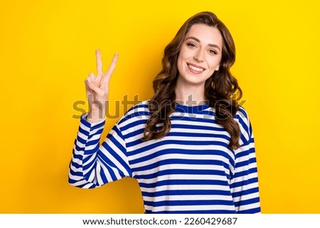 Photo of young stylish wearing pullover brown wavy hair lady smiling showing v-sign hello people friendly person isolated on yellow color background