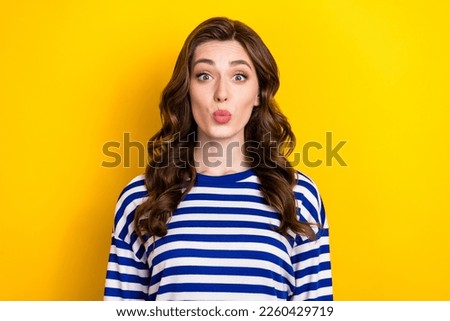 Photo of adorable sweet young lady wear striped shirt sending you kiss isolated yellow color background