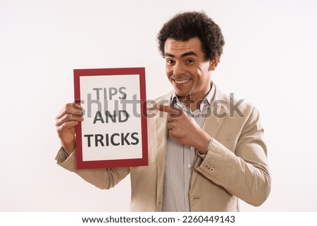 Image of businessman holding paper with text  tips and tricks.