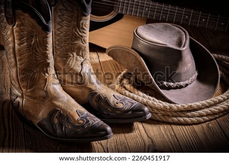 Country music festival live concert with acoustic guitar, cowboy hat and boots background Royalty-Free Stock Photo #2260451917