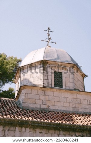Dome of a brick church with a cross on the background of the sky
