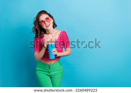 Portrait of cute good mood lovely woman with wavy hairstyle wear knit top hand hold cup look empty space isolated on blue color background