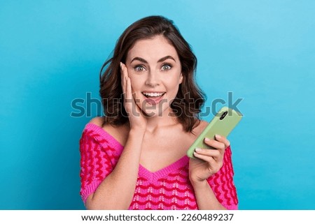 Photo of young funny emotional reaction speechless unexpected million subscribers blogger hold new apple phone isolated on blue color background